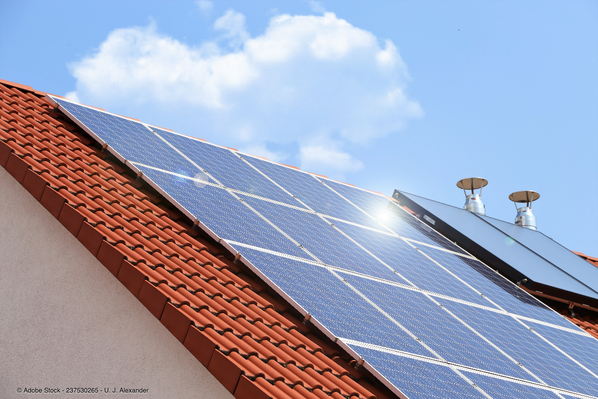Solarmodule auf einem roten Ziegeldach erzeugen nachhaltigen Strom und veranschaulichen Photovoltaik als Kapitalanlage für langfristige Investitionen.